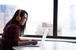 person using headphones on a laptop
