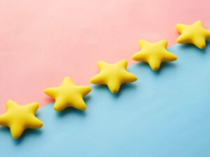 Five yellow stars arranged in a diagonal line across a split pink and blue background