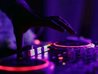 DJ playing a set on red-lit CDJs using a USB stick